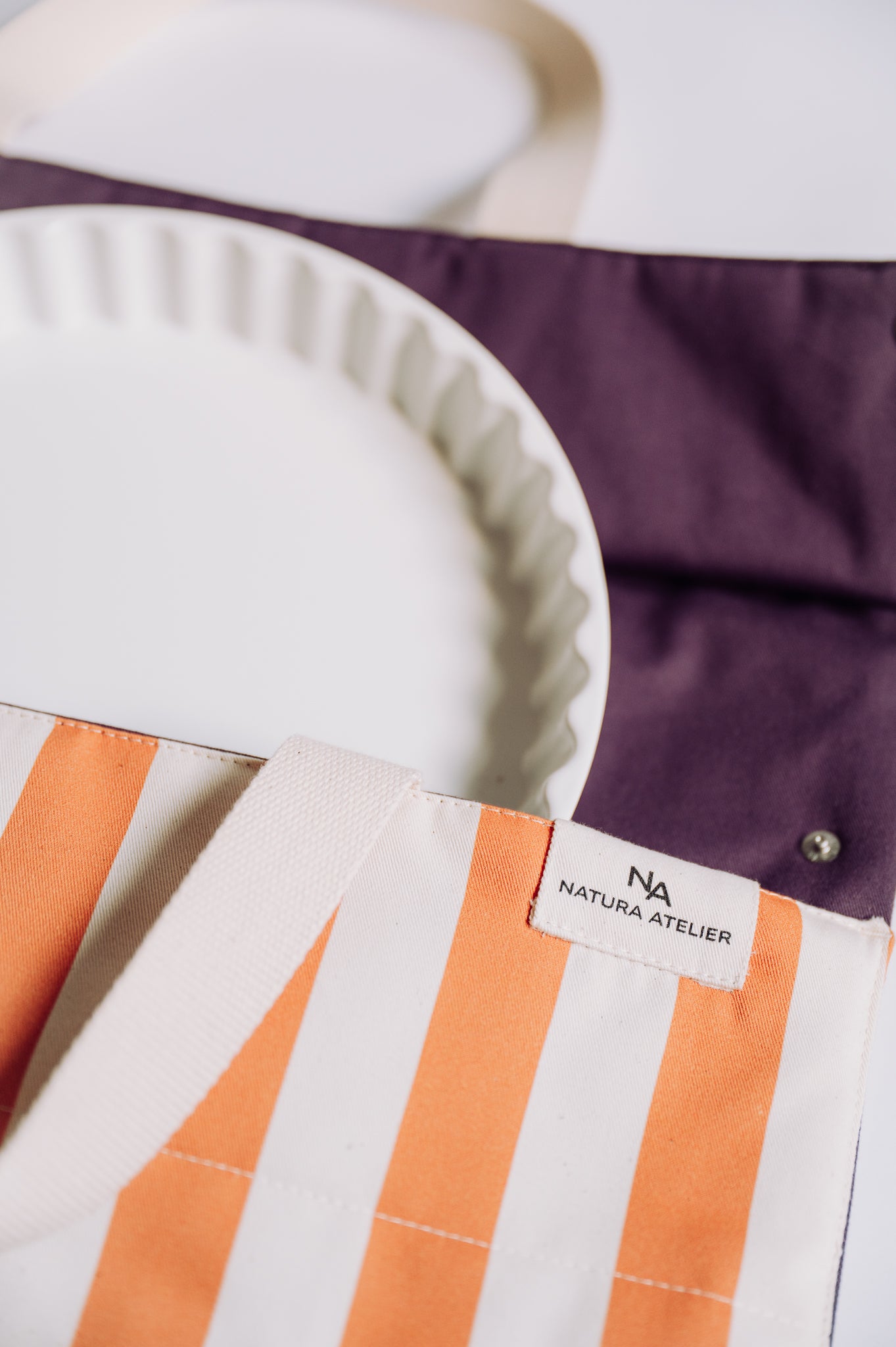 Close-up of a striped fabric with a visible brand label on a white background