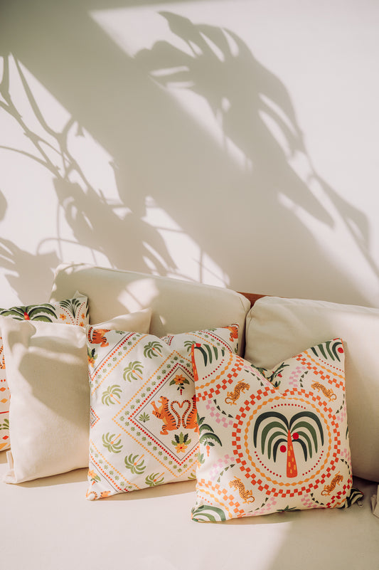 Decorative pillows with colorful Barbados pattern on a light-colored sofa.
