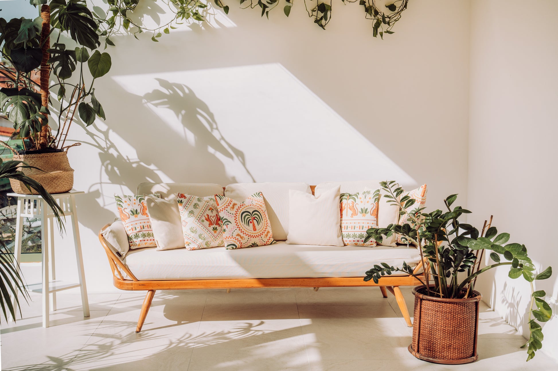 Ercol sofa with cushions surrounded by potted plants in a winter garden