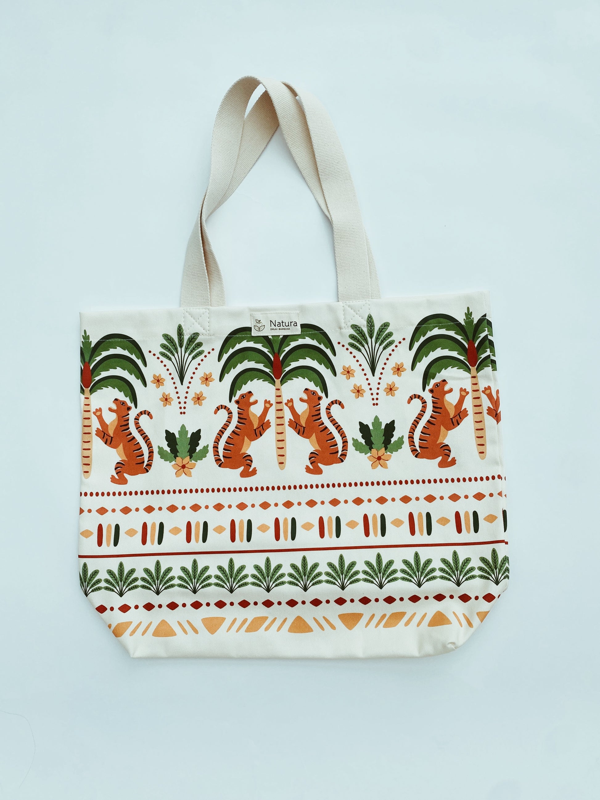 Tote bag with tiger and palm tree design on a light blue background